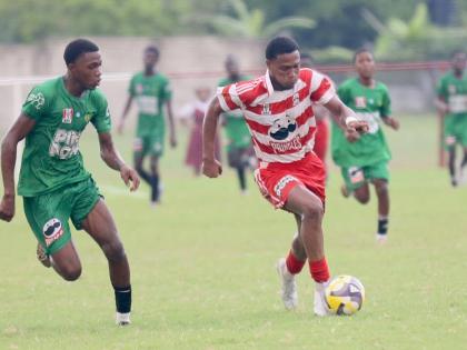 Glenmuir High School’s Oreel Miller (right) dribbles by St Mary Hig School’s Tyrique Banes during their daCosta Cup second-round encounter at Glenmuir yesterday. Miller scored twice in a 10-0 victory.