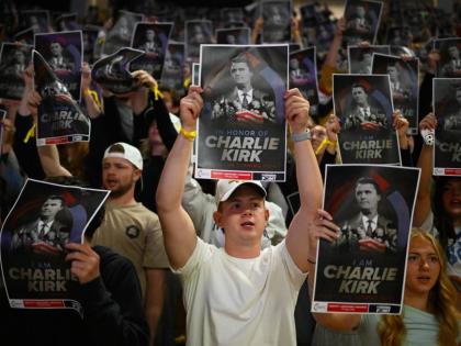 People hold posters of Charlie Kirk during a Turning Point USA rally at Utah State University, as a part of the organisation's push to memorialise Kirk, Tuesday, September 30, 2025, in Logan, Utah. (AP Photo/Alex Goodlett)