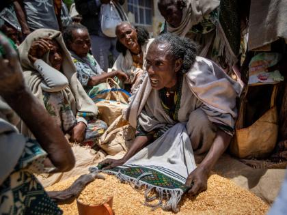 In this 2021 photo a woman is seen arguing with others over the allocation of yellow split peas after it was distributed by the Relief Society of Tigray in the town of Agula, in the Tigray region of northern Ethiopia.