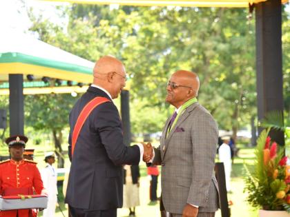Justice Kissock Laing (right) receiving his membership in the Order of Distinction in the rank of Commander from Governor General Sir Patrick Allen. 