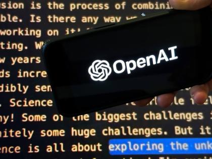 The OpenAI logo appears on a mobile phone in front of a screen showing part of the company website in this photo taken on November 21, 2023 in New York. (AP Photo/Peter Morgan, File)