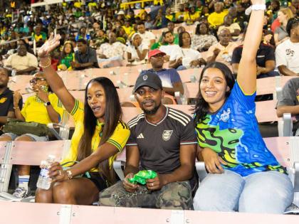 Brittany Thwaites (right), brand manager, WATA portfolio, Wisynco Group, shares a moment with football fans Lavonia (left) and Gerzan Williams (centre) in the stands at the National Stadium on Tuesday, October 14. The interaction formed part of WATA’s Ce