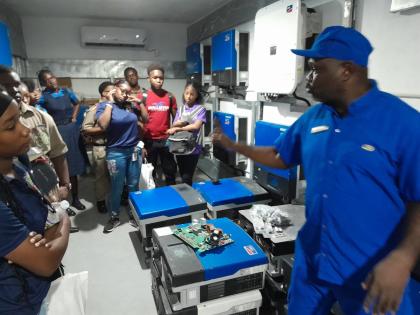 Michael Duncan, of the Grand Palladium Hotel, explains solar energy conversion to the visiting students and teachers.