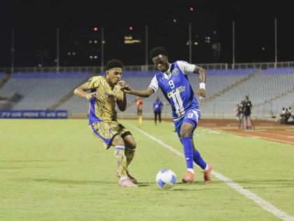 Mount Pleasant winger Daniel Green takes on Defence Force FC’s Christian Bailey during their Concacaf Caribbean Cup first-leg semi-final football game inside the Hasely Crawford Stadium on Wednesday, October 22, 2025.