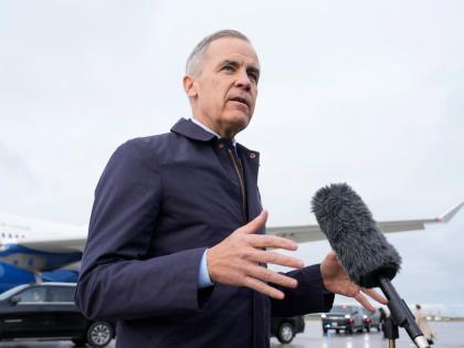 Canada Prime Minister Mark Carney speaks with members of the media before he boards a government plane in Ottawa on Friday.