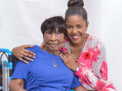 Centenarian Elsa Louise Atkinson is embraced by her daughter Michelle Williams, moments before receiving her Badge of Honour for 60 years of  service in the field of pharmacy.