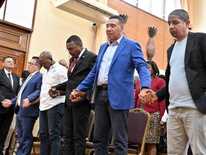 Prime Minister Dr Andrew Holness (second right) prays with his ministers (from left) Matthew Samuda, minister of water, environment and climate change; Pearnel Charles Jr, minister of labour and social security; Robert Morgan, minister without portfolio in