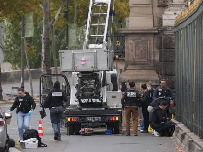 Police officers look for clues by a basket lift used by thieves at the Louvre museum in Paris. 
