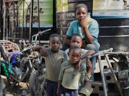 Children look at students attending school at a shelter for families displaced by gang violence in Port-au-Prince, Haiti.