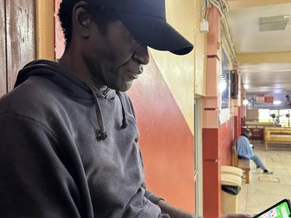 A stranded Rupert Roach sits on a bench at the Mandeville Regional Hospital, where he will have to wait out the hurricane before returning home.