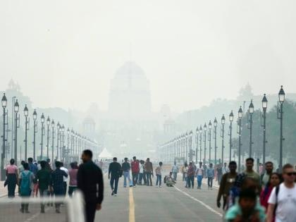 People walk on a street enveloped in smog, in New Delhi, India, on Tuesday, October 28, 2025.