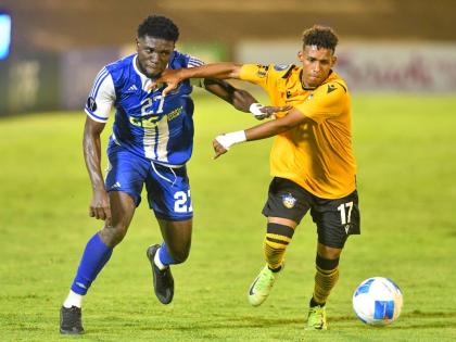 Ranaldo Biggs (left) of Mount Pleasant and Universidad O&M’s Reyvin de la Rosa battle for the ball during their Concacaf Caribbean Cup match at the National Stadium on September 30. Mount Pleasant won 2-0. 