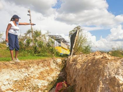 St Elizabeth Technical High School (STETHS) Acting Vice Principal, Patrine Daley-Chambers, points to the section of the perimeter wall that broke away during the passage of Hurricane Melissa.