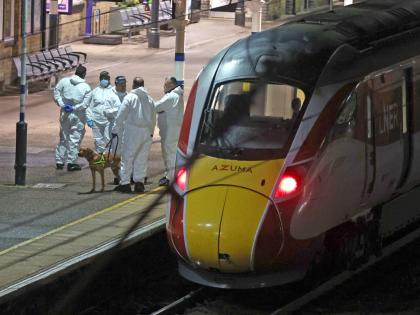 Forensic investigators on the platform by a train at Huntingdon station after a mass stabbing on a London-bound train in Cambridgeshire, England.