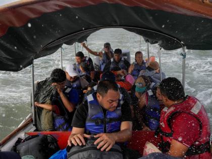 Luis Sanchez (centre) sits with other Venezuelan migrants on a boat leaving Gardi Sugdub on Panama’s Caribbean coast.