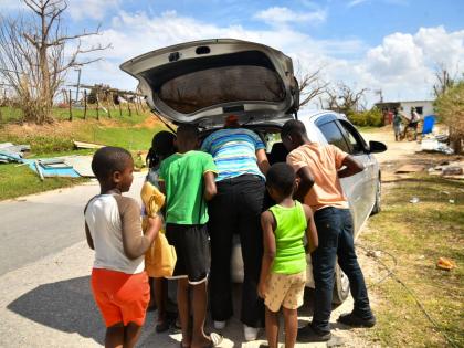 Children gather around to get porridge in Oxford, St Elizabeth.