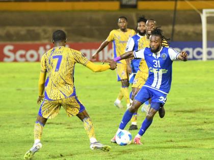 Demario Phillips (right)  of Mount Pleasant controls the ball as Jelani Felix of Defence Force FC tries to tackle during the Concacaf Caribbean Cup second leg semi-final match at the National Stadium on Wednesday night. Defence Force won 1-0.