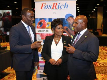 Minister of Industry Investment and Commerce Senator Aubyn Hill (right) engages FosRich Group CEO Cecil Foster during a Jamaica Investment and Housing forum at the Resort World hotel in Queens, New York, while Jamaica’s Consul General to New York Alsion 