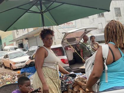 Yam seller Tesha Davis (left) negotiating the price of the produce with a customer.