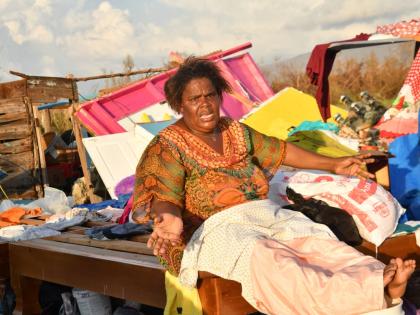 Nicola Gowdie, a resident of St Elizabeth, cries as she looks at the remains of her house that was damaged by Hurricane Melissa.