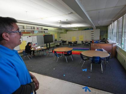 Principal Fernando Hernandez looks on in an empty classroom where a teacher is taking a lunch break at Perkins K-8 School Thursday, November 13, 2025, in San Diego. (AP Photo/Gregory Bull)