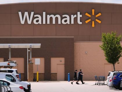 
Shoppers walk from the Walmart store on August 14, 2025 in Manchester, New Hampshire.