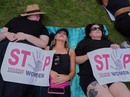 Participants lie on the ground holding signs that read: ‘Stop violence against women’, during a gender-based violence protest at the forecourt of the botanical gardens in Johannesburg, South Africa.