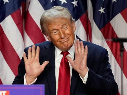 President Donald Trump showing hands at speaking engagement in 2024. 	 