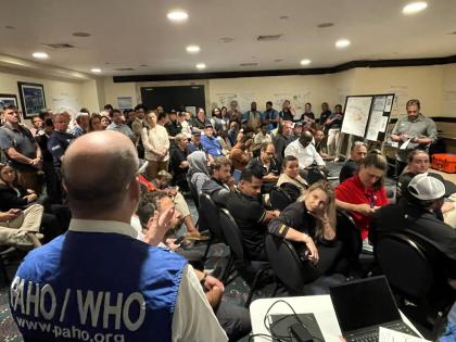 Responders listen to PAHO/WHO representative, Ian Stein, as he delivers his “catch of the day” update on post-Hurricane Melissa relief efforts. 