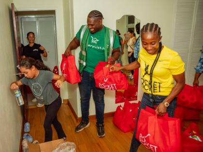Shelly-Ann Fraser Pryce, founder and head of the Pocket Rocket Foundation, and Alrick Johnson (centre), Logistics Lead for GroceryList Jamaica, gather care packages for distribution in areas affected by Hurricane Melissa.