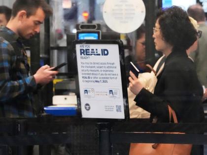 A Real ID sign is displayed as travellers wait to go through security check point at O'Hare International Airport in Chicago, May 23, 2025. (AP Photo/Nam Y. Huh, File)