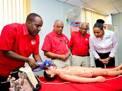 Heart Foundation of Jamaica (HFJ) Training Manager, Alonzo Mothersill (left), demonstrates an emergency procedure on a child mega code, during the November 26 handover of equipment donated by CHASE Fund at the HFJ’s Beechwood Avenue location. Observing (