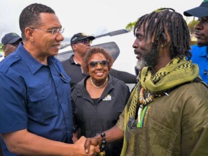 Prime Minister Dr Andrew Holness, shaking hands with Chief of the Accompong Maroons in St Elizabeth, Richard Currie, during a visit to the community on Sunday, November 30. Looking on is Minister of Culture, Gender, Entertainment and Sport, Olivia Grange.
