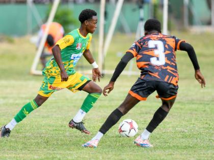 Demario Whyte (left) of Excelsior High School tries to go around Jahiem Fuller of Tivoli Gardens during an ISSA/WATA Manning Cup round-of-16 encounter at the Excelsior High School football field, yesterday. Excelsior won 3-2.