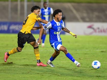 Mount Pleasant’s Kimoni Bailey makes a pass ahead of the chasing Anyelo Gomez of Universidad O&M during the Concacaf Caribbean Cup final at the National Stadium in Kingston last night. Jamaica drew the seond-leg game 2-2 after a 1-0 win in the Dominican 