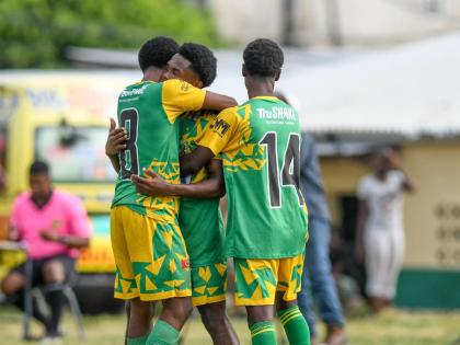 Excelsior High’s Terrence Williams (left) and Demario Whyte (right) hug teammate Kimarly Scott after his brilliant goal against Tivoli High in a Manning Cup second-round match at the Excelsior playing field on Tuesday. Excelsior won 3-2.