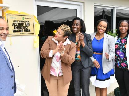 Minister of State in the Ministry of Health and Wellness, Krystal Lee (second left), applauds as she views the plaque dedicating the newly renovated Accident and Emergency Waiting Area at the Lionel Town Hospital in Clarendon, during the official opening o