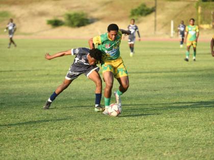 
Jamaica College’s (JC) Jamone Lyle and Excelsior High’s Shamarie Chambers get into an almighty tussle for possession during their ISSA/WATA Manning Cup quarterfinal football match at Stadium East yesterday. JC won the encounter 2-1.