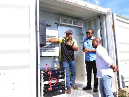 Agriculture Minister Floyd Green (centre), and acting CEO of the Rural Agricultural Development Authority, Garnet Edmondson (right), are shown features of one of the two 20-foot solar-powered cold-storage containers by RADA parish manager for St Elizabeth,