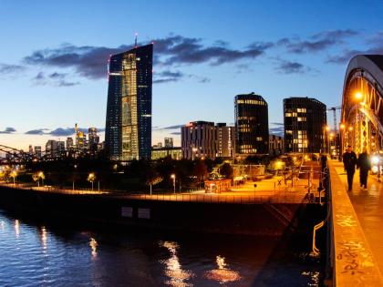 
People walk over a bridge near the European Central Bank in Frankfurt, Germany, on Sunday, October 26, 2025.