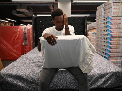 Dellon Hall, an employee of Strobe Etech Communications, is overcome with emotion after receiving a bed during the company’s handover of essential household items to staff affected by Hurricane Melissa on Tuesday.