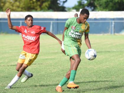 Ocho Rios High’s Dario James (right) turns away from Dimell White of Old Harbour High  during their ISSA Ben Francis KO round one match at Drax Hall Sports Complex yesterday.