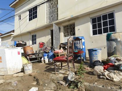 Ian Allen/Photographer 
Belongings are seen piled up on a street filled with mud in a section of Catherine Hall Montego Bay, St James, which was affected by Hurricane Melissa.