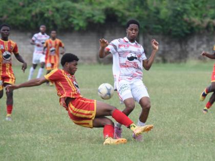 Ashley Anguin/photographer 
Glenmuir High School’s Dunsting Cohen (right) tries to evade the tackle of Cornwall College’s Khalid Fraser during their ISSA daCosta Cup quarter-final football match at Cornwall’s playing field yesterday. The game ended 1
