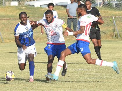 Gawain Austin (right) and Tarick Ximines (centre) of Portmore United challenge Mount Pleasant’s Warner Brown (left)  during their Jamaica Premier League match at Ferdi Neita Park yesterday.