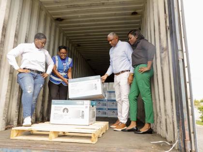 From left: Jannel Morrison, sales & marketing executive, Mabe; Marsha Burrell-Rose, manager – marketing, pr & missions, Food For The Poor; Philip Roach, commercial director, Unicomer; and Georgia Williams, purchasing manager, Courts, assist with the offl