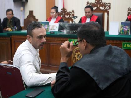 Australian national Lamar Ahchee, left, who is on trial on accusation of attempting to smuggle cocaine into Indonesia, talks to his lawyer during his sentencing hearing at the district court in Denpasar, Bali, Indonesia on December 18, 2025. 