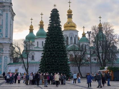 People walk around the Christmas tree in front of St. Sophia Monastery in central Kyiv, Ukraine, Wednesday, Dec. 10, 2025.