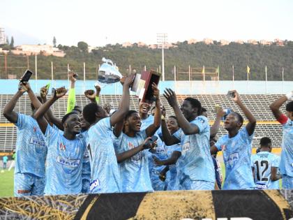 Members of the St Catherine High football team celebrate with the trophy after defeating defending champions Mona High in the Walker Cup KO final at the National Stadium yesterday. 