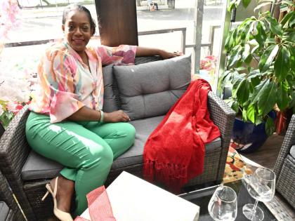 Photos by Rudolph Brown/Photographer 
Suzette Dawkins poses beside a festive red throw, styled on a loveseat, one of the simple décor updates she recommends for adding warmth and colour to a space at Christmas.